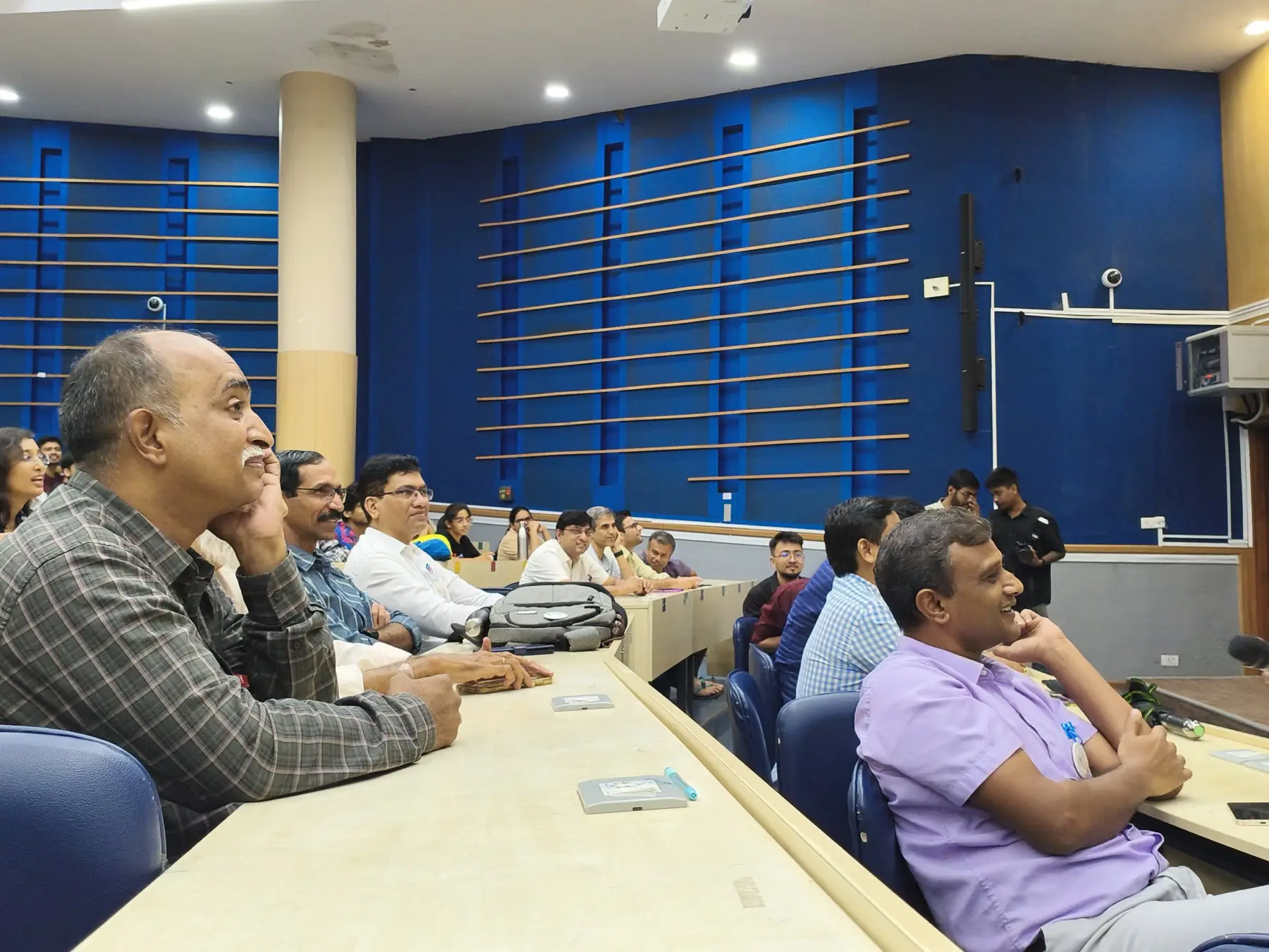 Faculty seated along the front table of the lecture hall