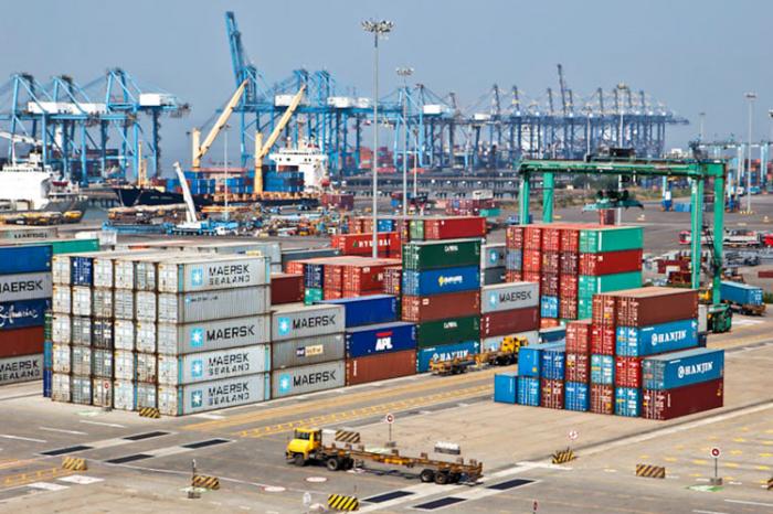 Stacked shipping containers and gantry cranes at a container terminal